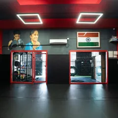 A view of our facility, showing the caged area for sparring and the strength and conditioning section. We have everything a fighter needs to level up.