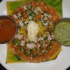 Our special open-faced masala dosa, a colourful and delicious breakfast option. It's topped with a mix of vegetables, coconut, and herbs, and served with a dollop of butter, making it both healthy and tasty.