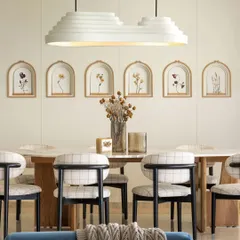 The dining space is all about harmony. An organic-shaped marble table is illuminated by a custom-made layered light installation, surrounded by comfortable black-stained dining chairs. The accent wall features niches with delicate, hand-painted floral artwork, adding a personal and artistic touch.