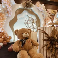 A cute teddy bear prop sitting amongst the stylish decor, adding a touch of softness to the modern theme.