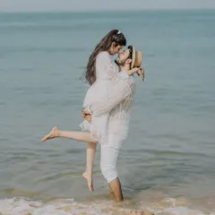 A playful lift in the gentle waves of a Goan beach. This shot is full of joy and captures the fun, carefree spirit of a coastal pre-wedding shoot.