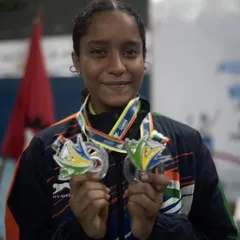 **A Kiss for the Medals.** A proud Aaditya Yadav shows off her hard-earned medals from the World Deaf Badminton Championship. Each one represents a story of perseverance and dedication.