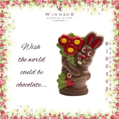 This chocolate bunny is holding a large bouquet of flowers, showcasing detailed molding and colorful accents.