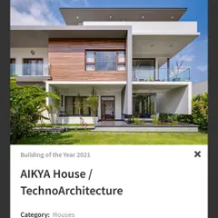 The 'AIKYA House', nominated for Building of the Year, features a clean, modern facade with cantilevered balconies and a balanced composition of wood, glass, and white walls.