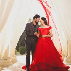 A classic pre-wedding pose. The bride to be wears our off shoulder red ball gown, which contrasts beautifully with her partner's checkered suit.
