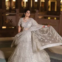 A bride twirls in her beautiful silver lehenga, her joy evident in her smile. We love capturing these moments of happiness and movement.