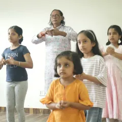The foundation of our teaching lies in the sacred Guru-Shishya tradition. Here, one of our senior gurus guides our youngest students as they learn their first mudras, ensuring that the art form is passed on with care and respect.