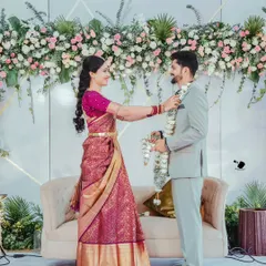 We designed this elegant stage backdrop for Sanchitha and Vinay's special day. The arrangement features a dense wall of pink and white roses mixed with green foliage, creating a sophisticated and picturesque setting for their ceremony.
