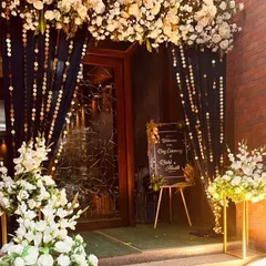 An elegant and chic entrance for Rishi and Avanti's ring ceremony. The combination of white flowers, dark drapes with gold sequin strings, and a simple welcome easel creates a look of modern sophistication.