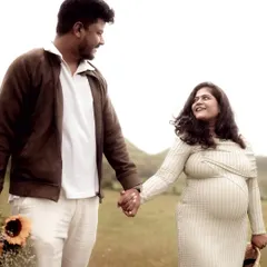 A sweet, candid moment of a couple walking hand-in-hand through a field. The loving glance they share speaks volumes about their connection and shared excitement.