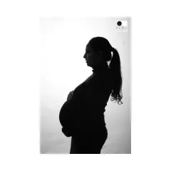This silhouette shot features the mother-to-be with her hair in a ponytail, creating a clean and modern outline against the bright background.