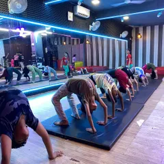 Teamwork makes the dream work. This is our group gymnastics class, where students learn together, practicing fundamentals like the backbend to build flexibility and strength in a synchronized, supportive environment.
