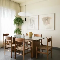 This dining space is centered around a custom oak table with intersecting surfaces and woven-seat chairs I designed. I believe a dining table is a place for connection, so I focus on creating pieces that are both beautiful and built to host a lifetime of memories.