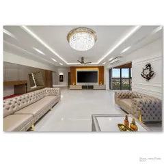 A wide view of a luxurious living room in Tata Aquelia Heights, featuring plush tufted sofas and a grand crystal chandelier. The expansive layout and pristine white marble floors reflect a sense of opulence and modern grandeur.