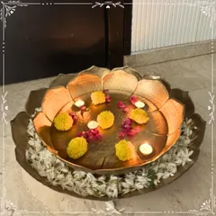 I love creating pieces that bring tranquility and beauty to your home. This large, handcrafted metal urli, styled with floating marigolds and tea lights, creates a serene and welcoming centerpiece, perfect for any festive occasion or to simply elevate your daily living space.