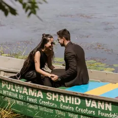 A close-up, candid shot of the couple sharing a smile in the boat. This image focuses on their happy and relaxed interaction during their serene pre-wedding shoot.