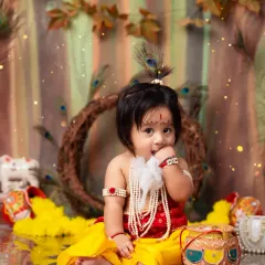 Our little Kanha, complete with a peacock feather and a mischievous bite of butter. These details make our themed shoots special.