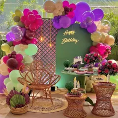 A beautiful and bohemian-chic 40th birthday party. This outdoor setup includes a unique color palette, a stylish peacock chair, and modern floral arrangements.