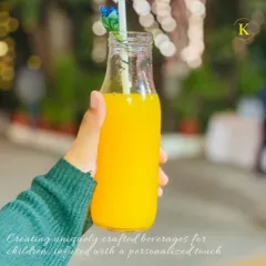 A close-up of a bright orange-flavored drink, specially crafted for a child. The cute floral straw adds a whimsical touch that kids love, making hydration fun.