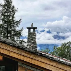 The stone chimney detail on our Verbier chalet, set against a backdrop of clouds and mountains. We believe in using local craftsmanship and materials to create details that are both beautiful and authentic to the location.