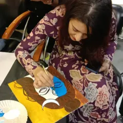 A student completely focused as she adds color to her painting of Lord Shiva. The act of painting a divine form can be a very calming and centering experience, allowing the artist to connect with her inner self.