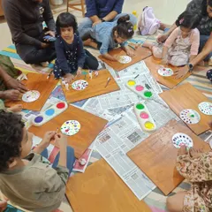 After the story, it's time for hands-on fun. This creative craft session shows children deeply focused on their dot painting activity, a wonderful way to develop fine motor skills and express their artistic ideas.