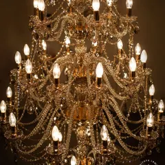 A detailed look at our magnificent multi-tiered crystal chandelier. Each arm is draped with shimmering crystal beads that reflect and refract light, creating an unparalleled sparkle. This fixture is a testament to classic European design and meticulous craftsmanship.