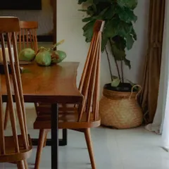 My 'Alto' dining chairs surrounding a live-edge teak table. The high, spindled backrest is inspired by classic Windsor chairs but with a modern, minimalist feel.
