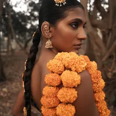 A profile shot that highlights the traditional South Indian jewelry and braided hairstyle. The soft, natural light of the forest setting adds a beautiful, gentle quality to the image.