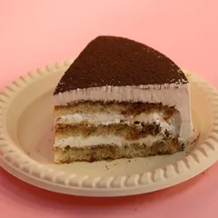 A slice of our classic Tiramisu. It features layers of coffee-soaked ladyfingers and creamy mascarpone, finished with a dusting of cocoa powder.