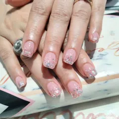 A subtle yet sparkly look on short, natural nails, featuring a sheer pink base with a delicate silver glitter gradient on the tips.