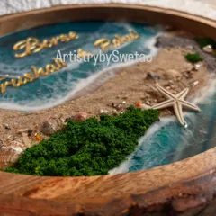 A close-up of the details on the ocean nameplate. You can see the texture of the sand, the tiny shells, and the lush green moss accents that bring the coastal scene to life.