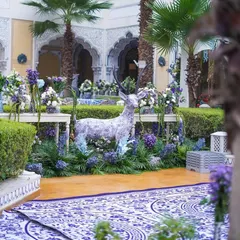 A whimsical touch with a deer statue covered in the event's signature blue and white pattern, surrounded by a bed of purple and blue flowers.