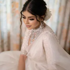 For a soft and romantic reception look, I crafted this textured messy bun. The face-framing wavy tendrils and the fresh white rose create a dreamy, effortless style that looks stunning in photos.