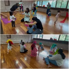 Children and parents dancing with colorful scarves during our "Banjo" collection. Using props like scarves helps children visualize the music and express themselves freely.