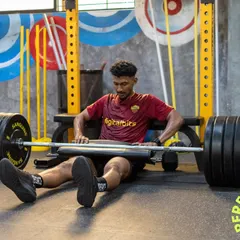 An athlete prepares for a heavy hip thrust, a key exercise for developing posterior chain power. This image showcases our high-performance equipment and the focused intensity of our strength sessions.