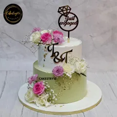 A beautiful two-tier engagement cake combining Black Forest and Butterscotch flavors. This 5kg creation is decorated with fresh pink and white carnations, gold leaf, and a custom initial topper.
