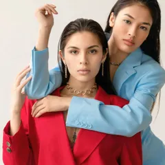 Two models pose together in a studio, one in a bold red power suit and the other in a cool blue one. This conceptual shoot showcases my ability to create striking, high-contrast images for brands and editorial features.
