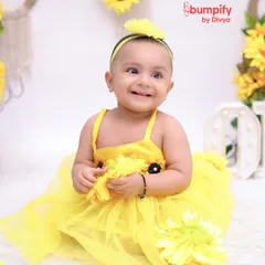 Our little sunshine is blooming with joy. This close-up from the sunflower-themed first birthday shoot captures a beautiful, radiant smile.