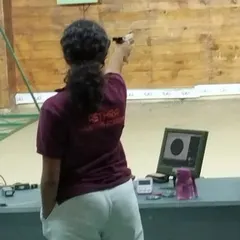 A student wearing our academy T-shirt competes in the 12th Karnataka State Sport Shooting Championship, with her shot displayed on the monitor.