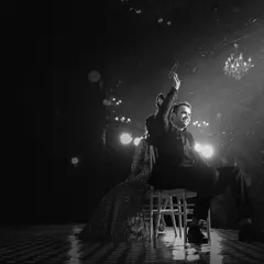 A dramatic black and white photo of a couple's sangeet performance on a rain-swept stage. This image captures the passion and theatricality of their dance, even amidst the elements.