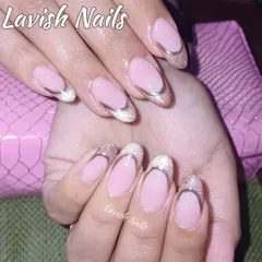 An elegant French manicure with a twist. These oval-shaped nails have a soft, glittery gold tip outlined with a fine silver chrome line for a double-accented, sophisticated finish.