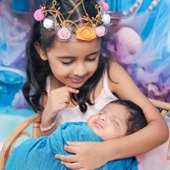 A close-up shot showing the older sister looking down at her newborn brother with so much love and wonder. These are the precious, unscripted moments I aim to capture.