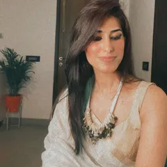 A candid moment in a simple off-white linen saree paired with a statement beaded necklace. This outfit is all about texture and shows how to make a minimalist ethnic look feel special.