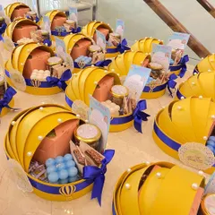 A fleet of our unique cradle-shaped baby announcement hampers, ready to share the happy news. The yellow and blue theme with hot air balloon details adds a touch of whimsy.