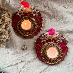 A top-down view of my handcrafted resin diyas with Ganesha idols. The rich red resin, gold details, and delicate flowers make these a beautiful addition to any festive celebration.