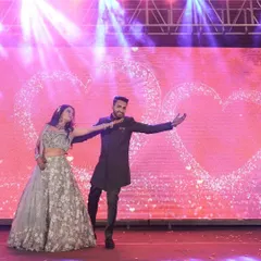 A beautiful shot from a romantic couple's duet against a backdrop of glittering hearts. We work with you to select the perfect song and style that captures the essence of your relationship for your sangeet dance.
