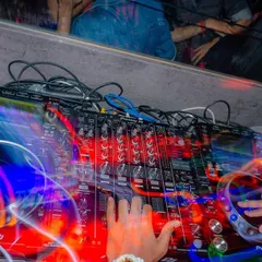 A long-exposure shot showing my hands at work on the Pioneer DJ mixer. This captures the dynamic action of live scratching and mixing that I bring to every performance.