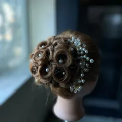 An intricate updo featuring beautifully crafted pin curls, each centered with a pearl. This advanced styling technique is perfect for creating a sophisticated and glamorous look.