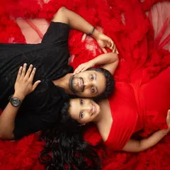 An aerial shot of a couple nestled in a sea of red tulle creates such a striking and intimate image. This creative studio setup focuses entirely on their connection and the love surrounding their little miracle.